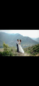 a couple in wedding clothes on a mountain range